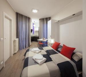 a bedroom with a large bed with red and white pillows at Metro Apartment in Collegno