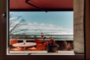 una ventana con vistas a un patio con mesa y sillas en findling-ferien Bern West, en Säriswil