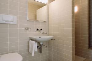 a bathroom with a sink and a toilet and a mirror at findling-ferien Bern West in Säriswil