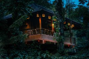 a tree house in the forest at night at Kalpavanam Heritage Resort in Thekkady