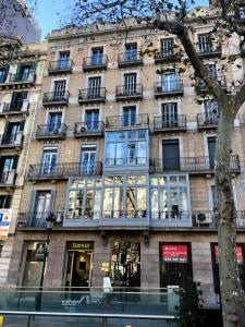 - un grand bâtiment avec des fenêtres sur le côté dans l'établissement Mr. Serrano Apartments, à Barcelone