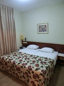 a bedroom with a bed with a floral bedspread at Lev yerushalayim - suites hotel in Jerusalem