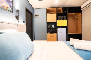 a bedroom with a white bed and a refrigerator at Emil Balaban Luxury Apart-Hotel in Bucharest