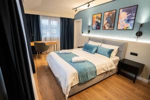 1 dormitorio con 1 cama grande con almohadas azules en Emil Balaban Luxury Apart-Hotel, en Bucarest