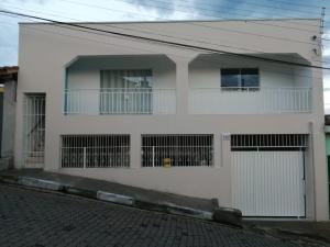 a white house with a gate and a balcony at Estalagem Cardoso in Cunha