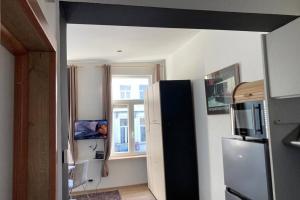 Elle comprend une petite cuisine avec un réfrigérateur et une fenêtre. dans l'établissement Magnifique Studio au 2ème étage, à proximité de la gare du midi!, à Bruxelles