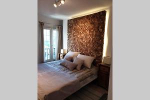 Un dormitorio con una cama grande con una pared de ladrillo. en Apartamento en la mejor zona de la Sierra junto a los remontes Reformado en 2021, en Sierra Nevada