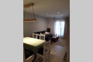 una sala de estar con una mesa y un sofá en Apartamento en la mejor zona de la Sierra junto a los remontes Reformado en 2021, en Sierra Nevada