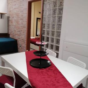 une table blanche avec un siège rouge dans une pièce dans l'établissement Oasi del Borgo, à Catane