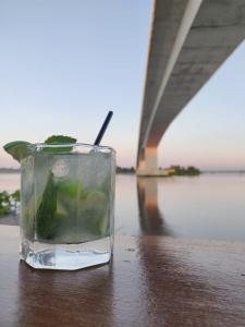 uma bebida num copo sentado numa mesa ao lado de uma ponte em Hotel Campestre Maguey em Mangue