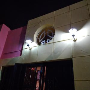 un reloj en el lateral de un edificio con luces en Ugarte Street, en Trujillo