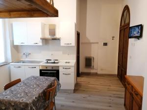 a kitchen with white cabinets and a table and a sink at Etrusco in Chiusi +13 photos