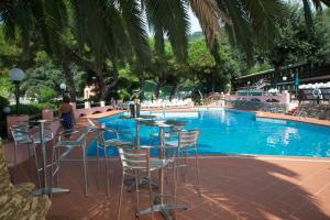 - une table et des chaises à côté de la piscine dans l'établissement Hotel Fiascherino, à Lerici