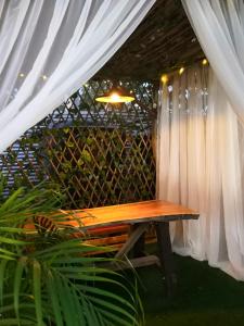 a wooden table in a room with a curtain at Hotel Campestre Maguey in Mangue