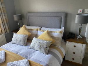 a bed with a white comforter and pillows at The Royal Oak Inn in Withypool