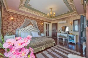 Schlafzimmer mit einem Bett, einem Spiegel und rosa Blumen in der Unterkunft Golden Horn Hotel in Istanbul