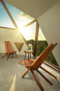 2 stoelen en een tafel in een kamer met uitzicht bij Mamasan Treehouses & Cabins in Tulum