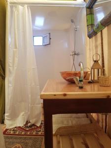 a bathroom with a wooden sink and a shower at Dune Merzouga Camp in Merzouga