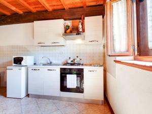 cocina con armarios blancos y fogones en Belvilla by OYO Farmhouse with Private Terrace, en Cocciglia