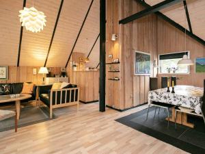 ブラーバンドにあるThree-Bedroom Holiday home in Blåvand 69の木製の壁のリビングルーム、ダイニングルーム