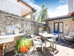 a patio with a table and chairs on a stone wall at Belvilla by OYO Farmhouse with Private Terrace in Cocciglia