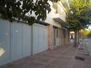 una recinzione bianca accanto a un edificio di mattoni di Alto Unimev a Mendoza