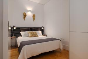 ポルトにあるFlores Street Apartmentsのベッドルーム1室(黒いヘッドボード付きのベッド1台付)