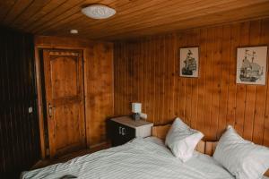 a bedroom with a bed and a wooden wall at Cabana Viking Colibița in Colibiţa