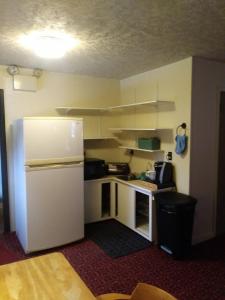 a small kitchen with a white refrigerator in a room at Rest Stop 6 Inn in Clarendon