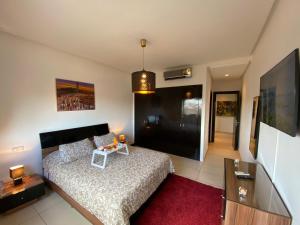 a bedroom with a bed and a table and a tv at Sweet Jacob's Appartment Gueliz City Center in Marrakesh