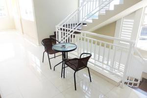 una mesa y sillas en una habitación con escaleras en Kelir Residence, en Kalibanteng-lor