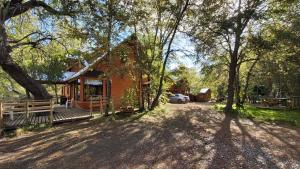 una cabaña en el bosque con entrada y árboles en Cabañas Tronco Mayen, en Las Trancas