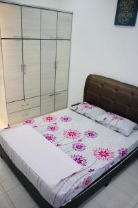 um quarto com uma cama com flores cor-de-rosa em Bismillah Homestay Muslem NETFLIX UNIFI HIGH SPEED em Kamunting