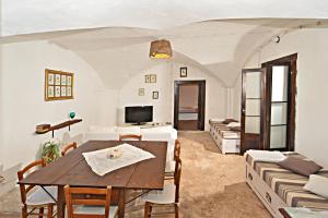 a living room with a table and chairs and a tv at Masseria Spina Resort in Monopoli