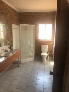 a bathroom with a toilet, sink and tub at Mercure Port of Echuca in Echuca