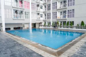 a large swimming pool in the middle of a building at Modern Spacious Studio Room Apartment at Taman Melati Surabaya By Travelio in Surabaya