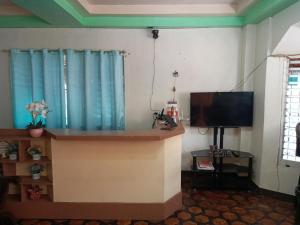 a living room with a flat screen tv and a flat screen at RedDoorz @ Calceta Street Cogon in Tagbilaran City