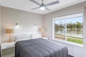 a bedroom with a bed and a large window at RACV Cobram Resort in Cobram