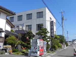 a building with a refrigerator in front of a street at Suikoen in Yonago