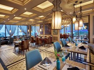 a restaurant with tables and chairs and a chandelier at Aira Boutique Hanoi Hotel & Spa in Hanoi