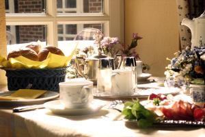 einen Tisch mit einem weißen Tischtuch mit Essen drauf in der Unterkunft Hotel Schäferhof in Schneverdingen