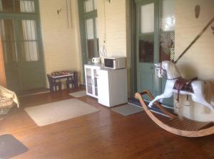 a room with a rocking horse and a kitchen at Chinnock B&B in Gilgandra