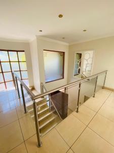 a staircase in a house with a glass railing at Comffies place in Johannesburg