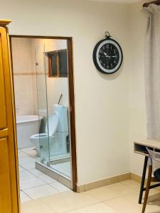a bathroom with a toilet and a clock on the wall at Comffies place in Johannesburg
