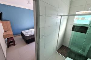 a shower with a glass door in a bathroom at Marmeu Enseada in Guarujá +33 photos
