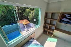 um quarto com uma janela com vista para um pátio em Marmeu Enseada com Hidro Aquecida Privativa no Guarujá