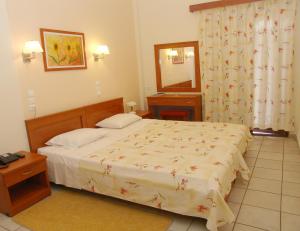 sypialnia z łóżkiem, umywalką i lustrem w obiekcie Hotel Kronio w mieście Olimpia