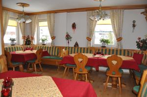 a dining room with two tables and chairs and windows at Bauernhof Haim in Pichl bei Aussee