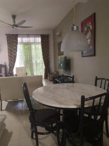 a dining room and living room with a table and chairs at Sutera Damai Homestay in Kampong Belah Dua