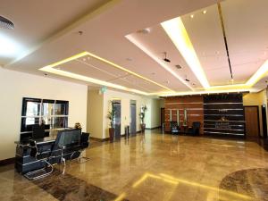 a large lobby with a hair salon with chairs and tables at Xclusive Maples Hotel Apartment in Dubai